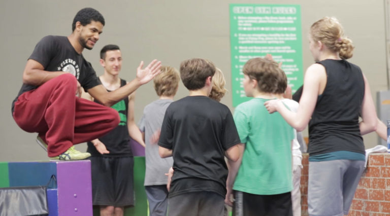 Coaches high-fiving Flying Frog students.